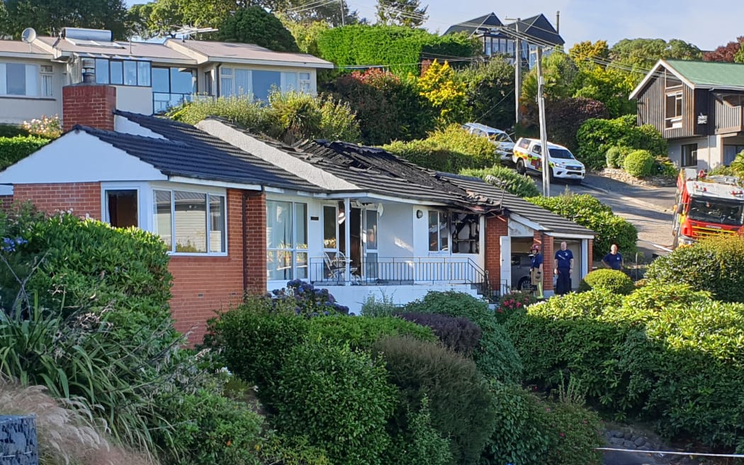 Fire crews assess the damage of a house fire at Challis Street in the suburb of Vauxhall in Dunedin where one person died.