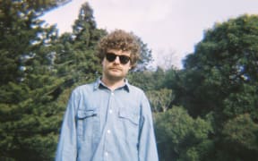 Jim Nothing standing in front of pine trees