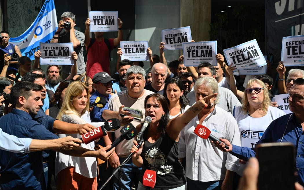 Carla Guadensi, centre, General Secretary of the Argentine Federation of Press Workers (Fatpren) and journalist for Telam Radio, speaks outside the state-owned news agency Telam headquarters during a protest as members of the Argentine Federal Police guard the entrance in Buenos Aires on 4 March, 2024.