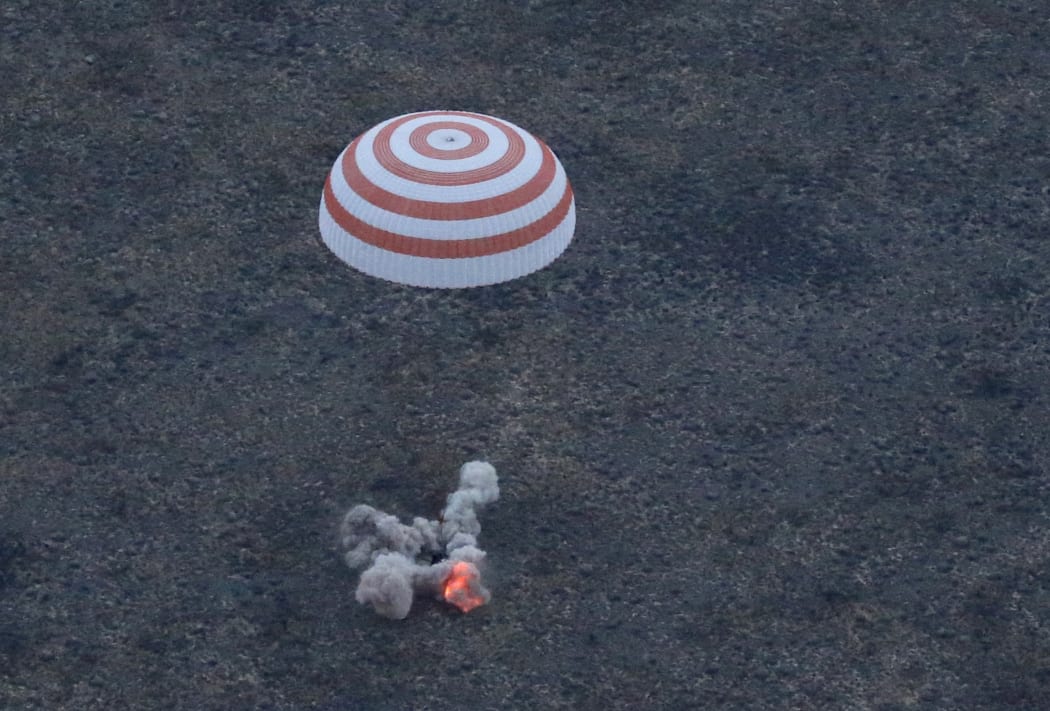 A three-person crew from the International Space Station lands safely in the steppes of Kazakhstan.