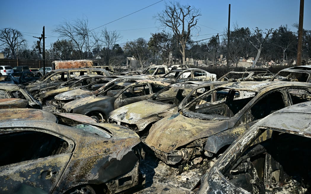 Cars belonging to the Altadena Auto Center dealership destroyed by the Eaton Fire remain parked in a lot, in Altadena, California, on January 10, 2025. Massive wildfires that engulfed whole neighborhoods and displaced thousands in Los Angeles have killed at least 10 people, authorities said, as California's National Guard soldiers readied to hit the streets to help quell disorder. News of the growing toll, announced late Thursday January 9 by the Los Angeles County Medical Examiner, came as swaths of the United States' second-largest city lay in ruins. (Photo by Frederic J. Brown / AFP)