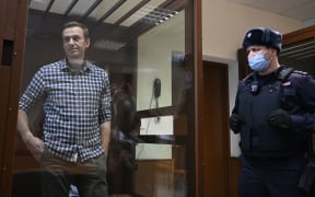 Russian opposition leader Alexei Navalny stands inside a glass cell during a court hearing at the Babushkinsky district court in Moscow on February 20, 2021.