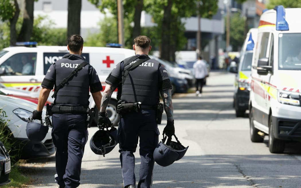 Two policemen at the scene of a school shooting in Graz in southeastern Austria, which has claimed multiple lives.