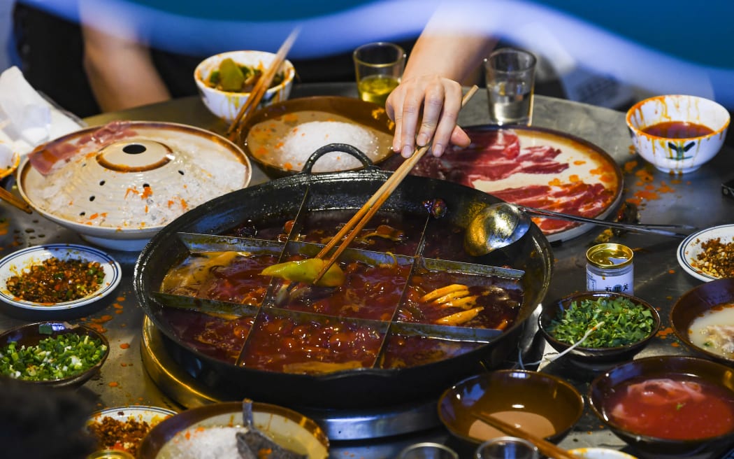 (221001) -- BEIJING, Oct. 1, 2022 (Xinhua) -- People enjoy a meal at a hotpot restaurant at a commercial street in southwest China's Chongqing Municipality, June 5, 2022. (Xinhua/Wang Quanchao) (Photo by Wang Quanchao / XINHUA / Xinhua via AFP)