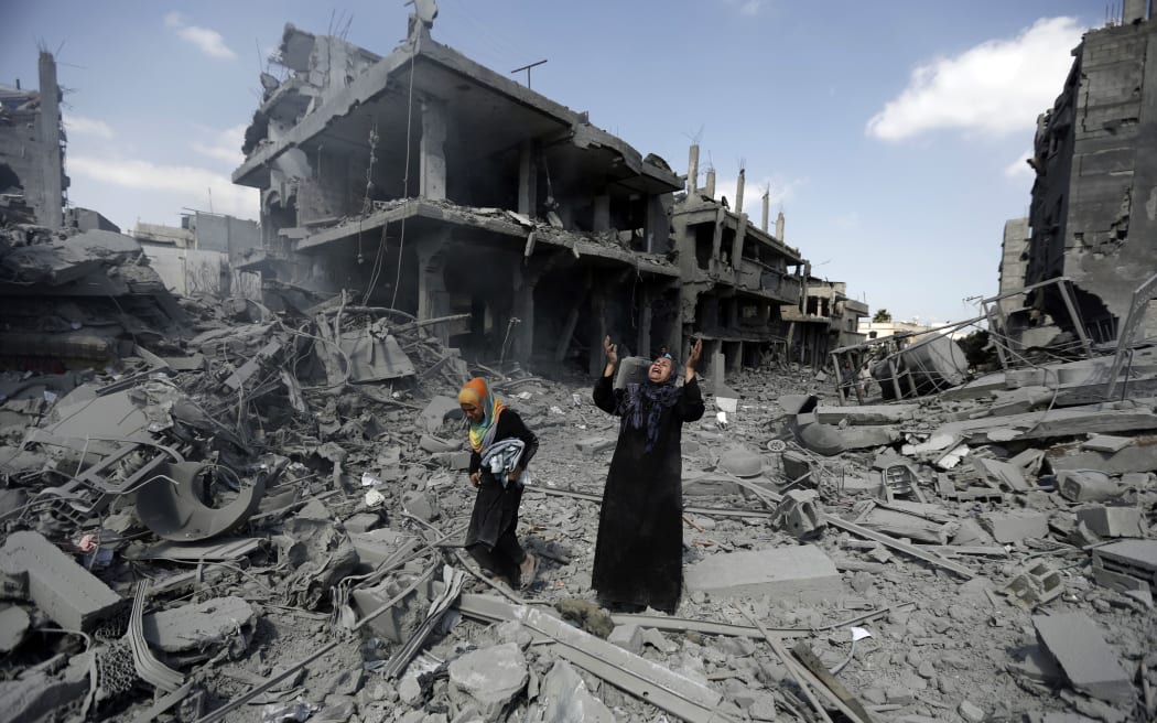 A Palestinian woman pauses amid destroyed buildings in the northern district of Beit Hanun in the Gaza Strip.