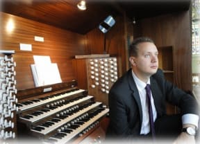 A portrait George Chittenden, Director of Music, St Paul's Cathedral in The Octagon, seated at the cathedral's pipe organ.