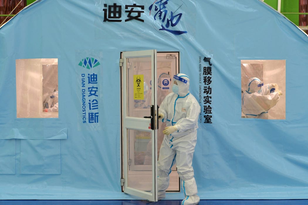 A staff member wearing personal protective equipment works at a temporary Covid-19 testing facility in north China's Tianjin on January 11, 2022, after authorities ordered the testing of all 14 million residents.