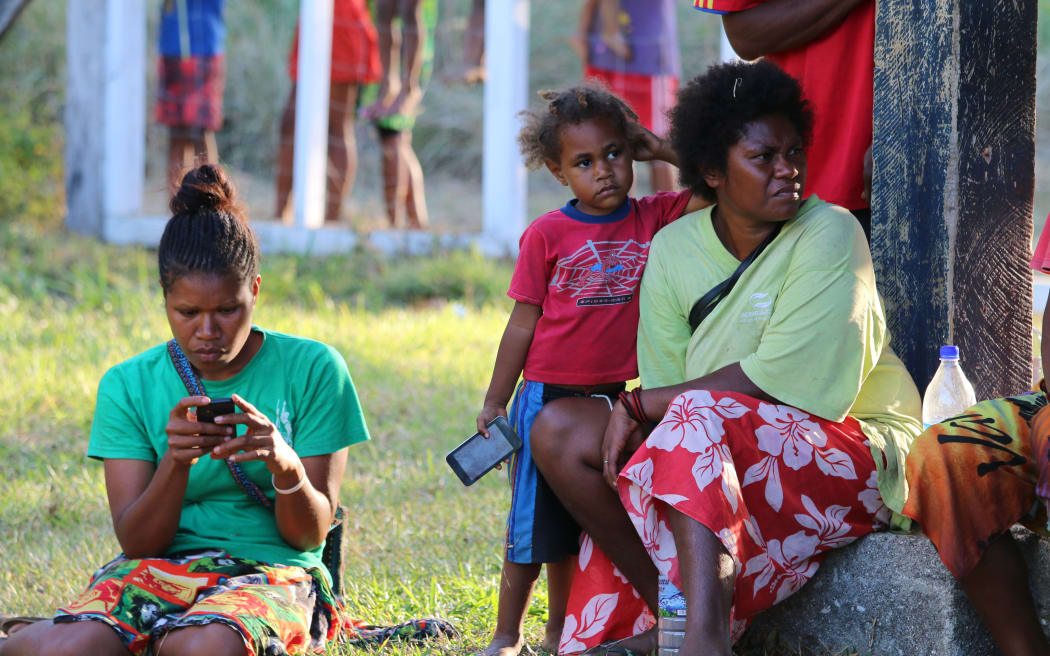 Women and children on Ambae at the airport to farewell the sick and elderly who are being transported off the island.