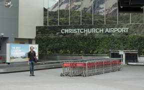 Hamish stqanding in front of a Christchurch airport baggage carousel