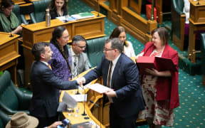 Finance Minister Grant Robertson (centre) and Deputy Finance Minister Megan Woods (behind him with red box) hand over copies of the Budget 2023 to leaders of other parties, 18 May 2023.