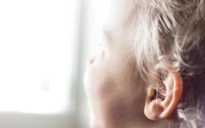 A young child looks out a window