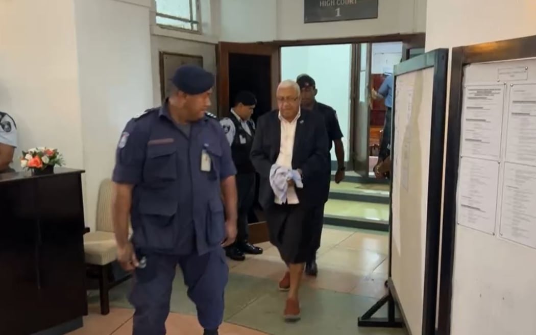 Bainimarama walks out of the Suva High Court and escorted by police officers to the be taken to jail. 9 May 2024