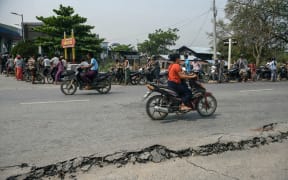 Motorists wait in line at a petrol station next to a damaged road in Mandalay on March 29, 2025, a day after an earthquake struck central Myanmar. Rescuers dug through the rubble of collapsed buildings on March 29 in a desperate search for survivors after a huge earthquake hit Myanmar and Thailand, killing more than 150 people. (Photo by Sai Aung MAIN / AFP)