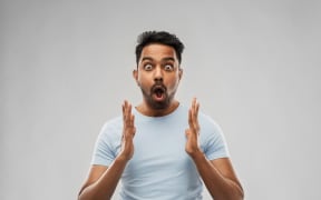 emotion, expression and people concept - scared man in t-shirt over grey background
