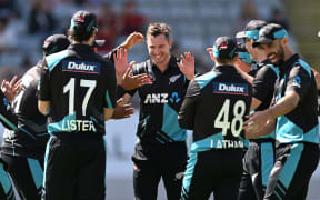 Adam Milne and team mates celebrate a wicket.