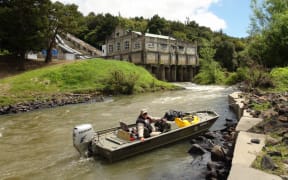 Millan Ruka on his boat with the Wairua power station in background.