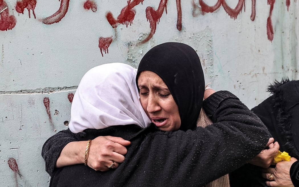 A woman consoles the mother (R) of Muhammad Ayman Ghazawi and Basel Ayman Ghazawi, two of three Palestinian men who were killed when undercover Israeli agents raided the Ibn Sina hospital in the city of Jenin, as she mourns during their funeral in the occupied West Bank city on January 30, 2024. Israeli forces shot dead three Palestinians at the hospital early on January 30, the Palestinian health ministry said, while the army said the three belonged to a Hamas "terrorist cell". The operation is the first such deadly incursion in years. (Photo by Zain JAAFAR / AFP)