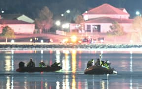 Rescue boats search the waters of the Potomac River after a plane on approach to Reagan National Airport crashed into the river outside Washington, DC, January 30, 2025. A regional jet from Kansas crashed into Washington's Potomac River after colliding mid-air with a military helicopter near Reagan National Airport, officials said January 29, prompting a major emergency response and grounding all flights. (Photo by ANDREW CABALLERO-REYNOLDS / AFP)