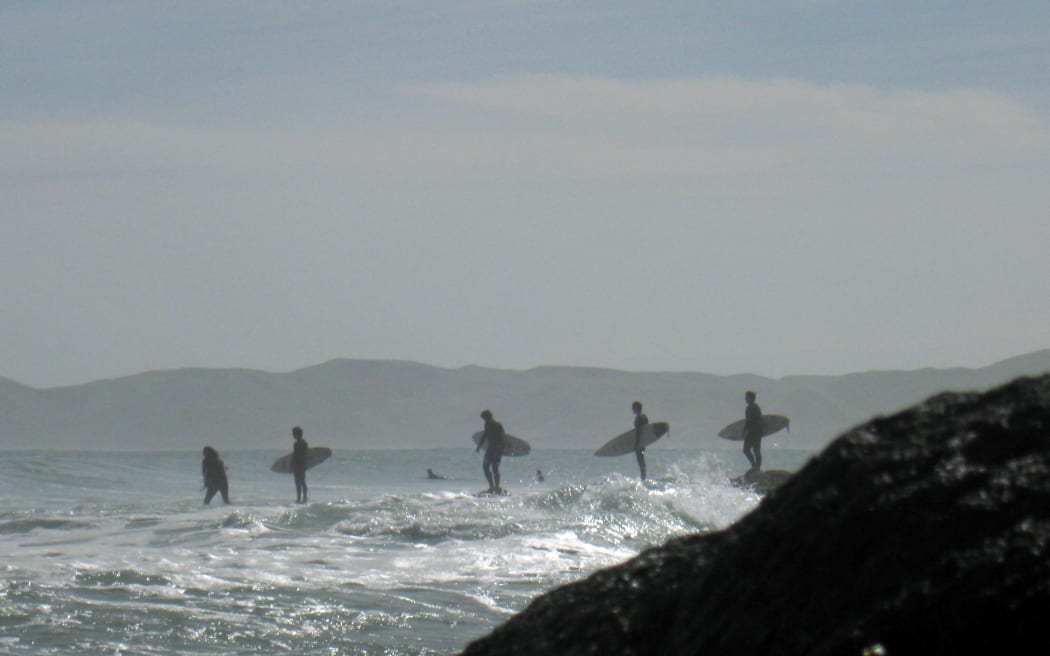 Surfers wait at Raglan.