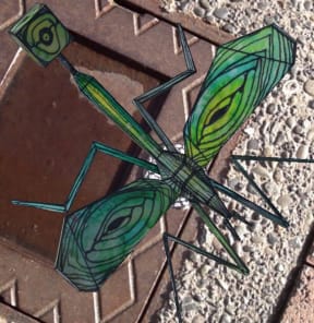 A green Awhi Creature rests on a wall feature.