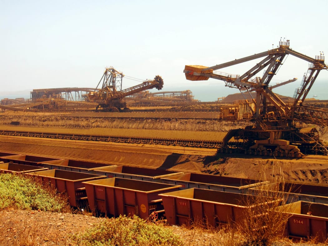 (FILES) This file photo taken on March 4, 2010 shows remote-controlled stackers and reclaimers moving iron ore to rail cars at Rio Tinto's Port Dampier operations in Western Australia's Pilbara region.