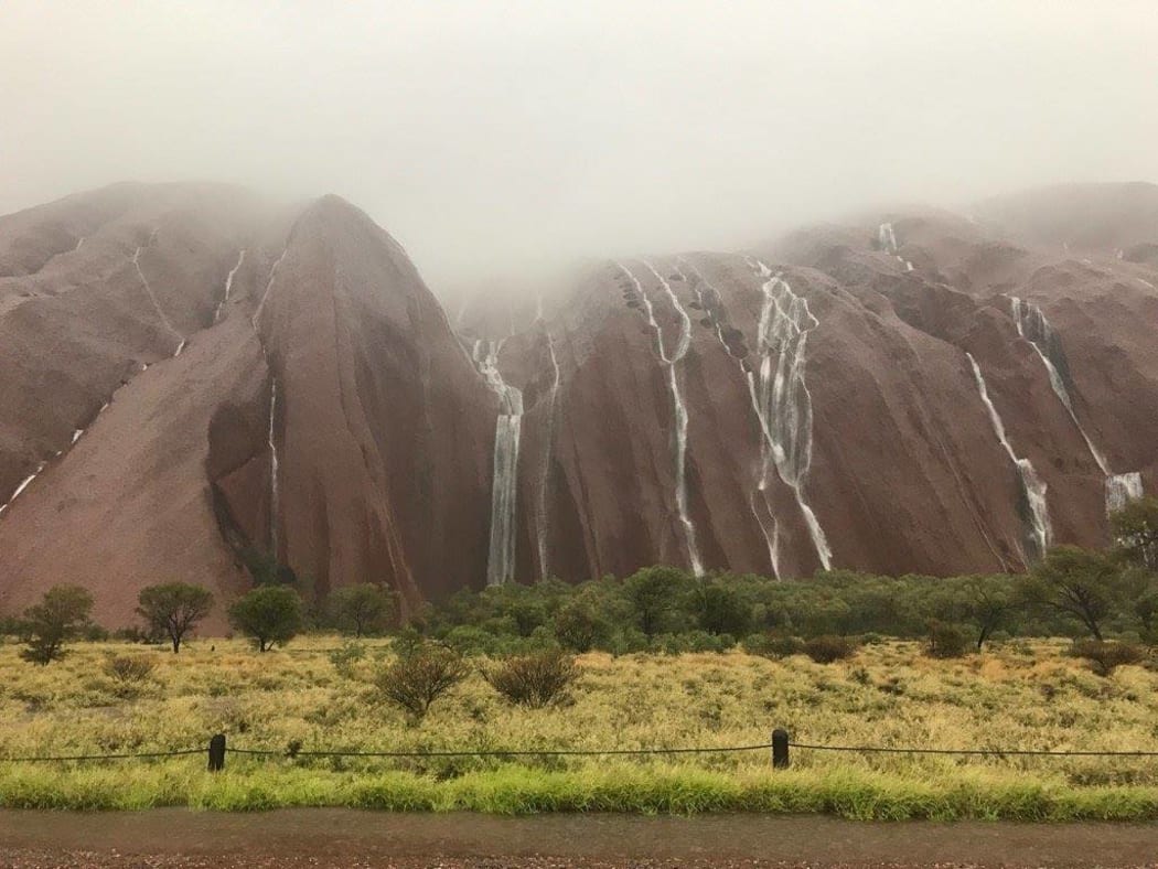 Waterfalls cascade down Uluru after flash flooding in central Australia
