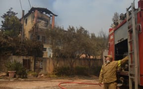 A house is burning in a wildfire in Varnavas, north of Athens, on August 12, 2024. Greece is battling several wildfires on August 11, with smoke covering parts of the capital Athens in a haze, amid warnings for extreme weather conditions for the rest of the week.