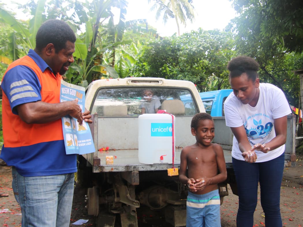 UN staff working with government officials to teach correct handwashing techniques in Vanuatu.