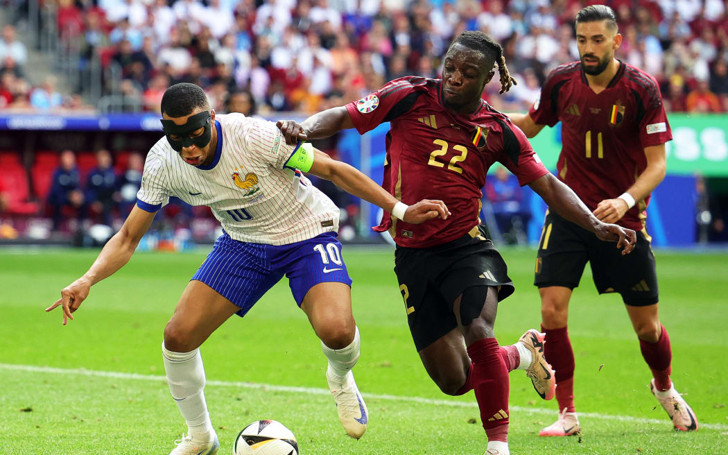 France's Kylian Mbappé (L) in action against Belgium's players Jérémy Doku and Yannick Carrasco during their Euro 2024 round of 16 match.