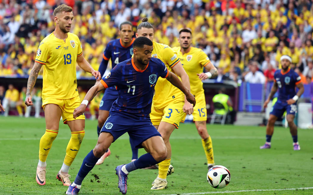 02 July 2024, Bavaria, Munich: Soccer, UEFA Euro 2024, European Championship, Romania - Netherlands, final round, round of 16, Munich Football Arena, Cody Gakpo of the Netherlands (l) and Romania's Radu Dragusin fight for the ball. Photo: Daniel Karmann/dpa (Photo by DANIEL KARMANN / DPA / dpa Picture-Alliance via AFP)