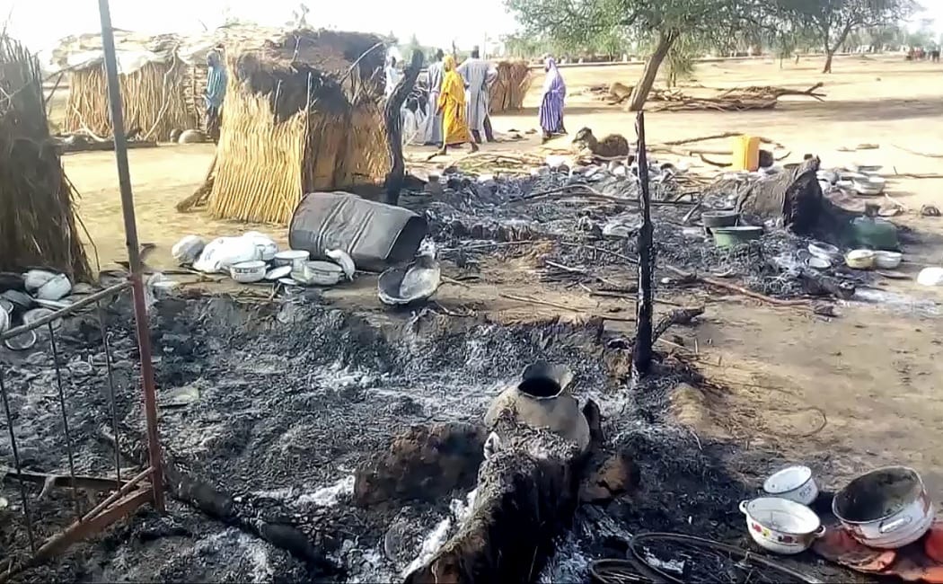 Smoldering ashes are seen on the ground in Budu near Maiduguri on July 28, 2019, after the latest attack this weekend by Boko Haram fighters on a funeral in northeast Nigeria