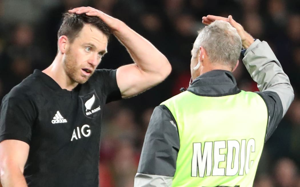 All Black fullback Ben Smith heads off the field for a concussion test,