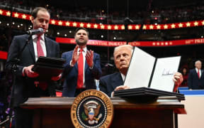 US President Donald Trump holds an executive order announcing the US withdrawal from the Paris Agreement, after his inauguration in Washington, DC, on Jan. 20, 2025.