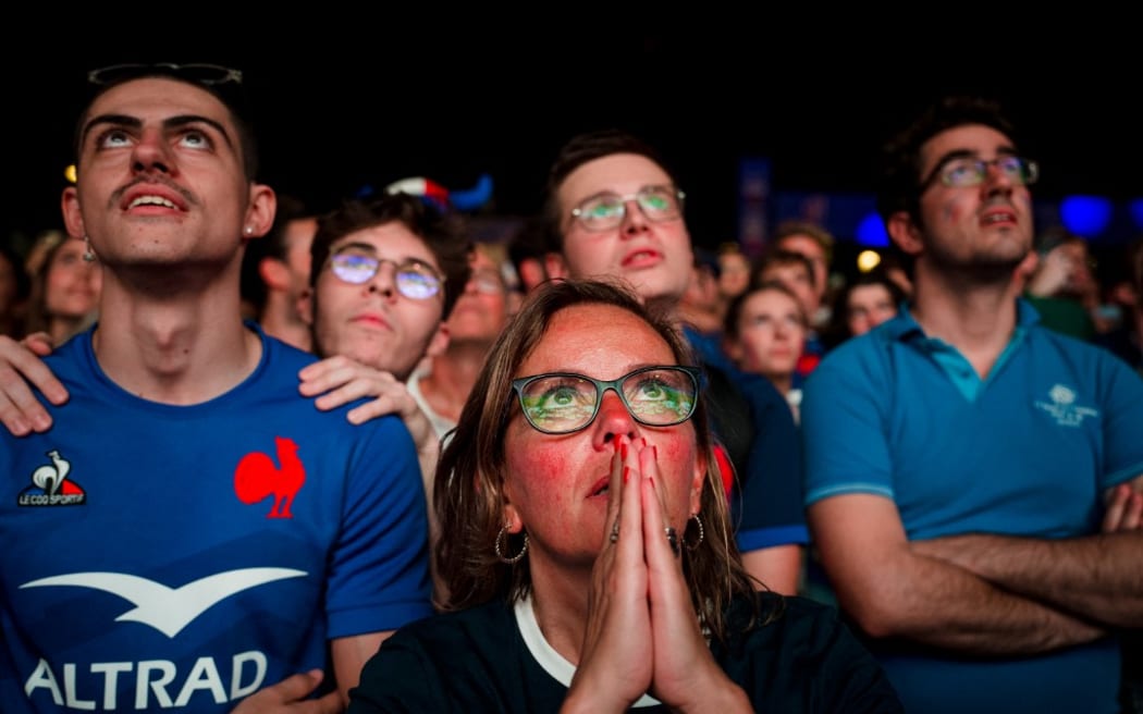 French supporters look on as New Zealand players perform the Haka prior to the opening match of the 2023 Rugby World Cup between France and New Zealand at a fan zone at Place de la Concorde in Paris on September 8, 2023. (Photo by Dimitar DILKOFF / AFP)