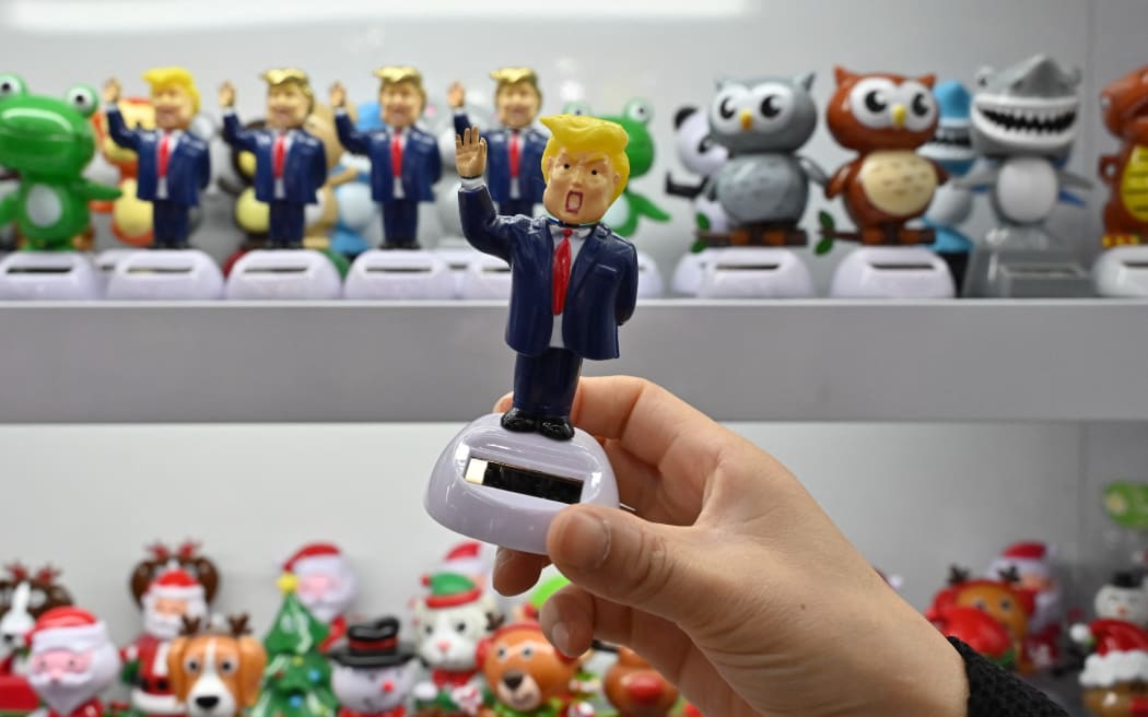 A shop owner holds a toy featuring US President Donald Trump at the Yiwu International Trade Market in Yiwu, China’s eastern Zhejiang province on April 10, 2025. US President Donald Trump abruptly paused tariffs on most countries, sparking euphoria on global markets on April 10, but upped the ante on a brutal trade war with superpower rival China. (Photo by ADEK BERRY / AFP)