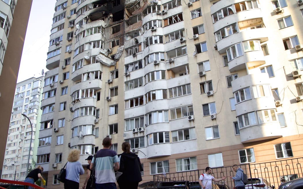 People stand outside an apartment block in the Solomianskyi district damaged by an overnight Russian attack in Kyiv, Ukraine, on June 6, 2025. On Friday night, June 6, four people die and at least 20 others are injured in a Russian missile and drone attack on Kyiv. In particular, three rescuers of the State Emergency Service of Ukraine die and nine others are injured while responding to the consequences of the nighttime attack in the Ukrainian capital. Falling debris and strikes are reported in six districts of Kyiv. (Photo by Kirill Chubotin/Ukrinform) NO USE RUSSIA. NO USE BELARUS. (Photo by Ukrinform/NurPhoto) (Photo by Kirill Chubotin / NurPhoto via AFP)