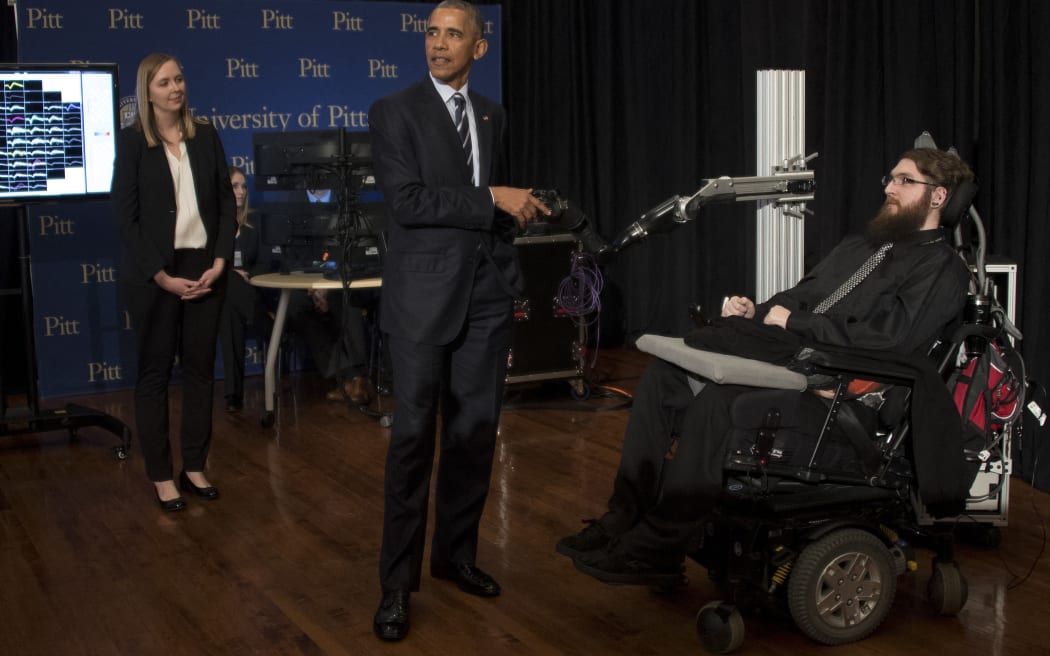 US President Barack Obama (C) speaks with neuro interface patient Nathan Copeland (R) as he tours innovation projects at the White House Frontiers Conference at the University of Pittsburg in Pittsburg, Pennsylvania, on October 13, 2016.