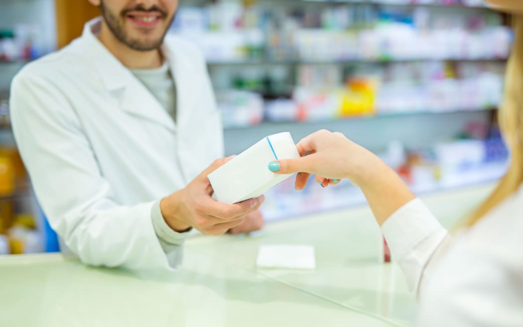 Experienced pharmacist counseling female customer in modern farmacy