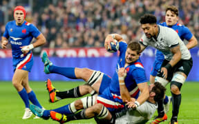 France's Paul Willemse is tackled by Sam Whitelock and Ardie Savea of New Zealand.