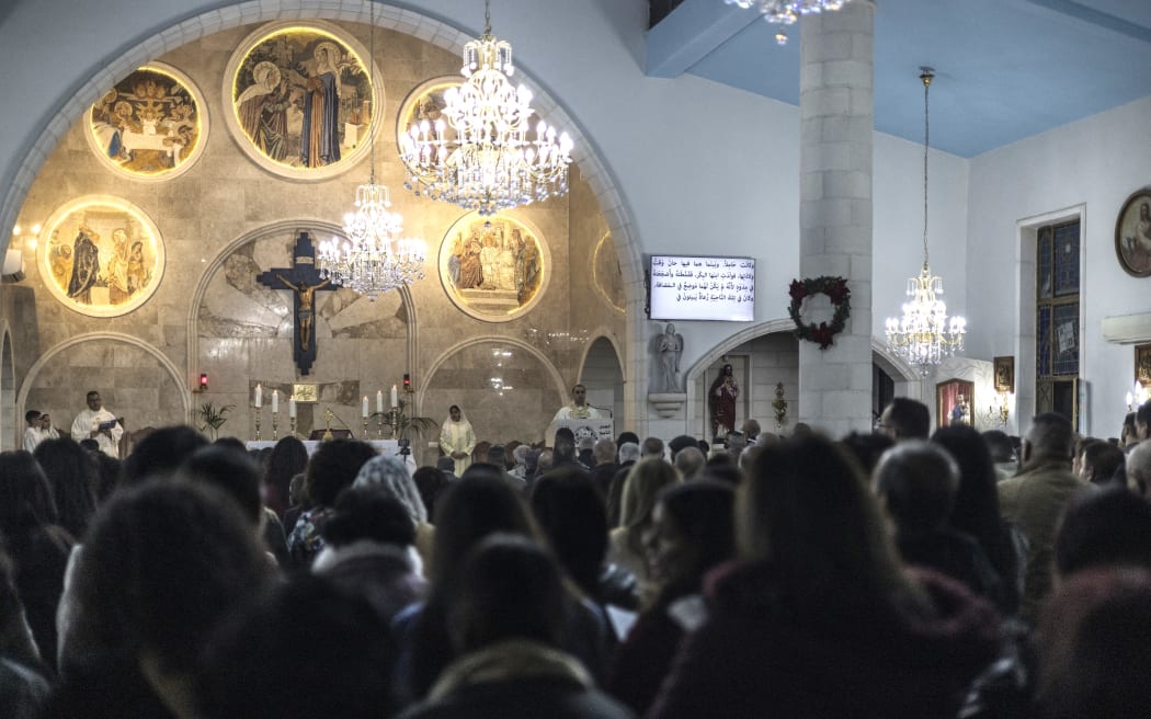 Katolicy tłoczą się przed kościołem Nawiedzenia, gdzie, jak się uważa, Dziewica Maryja odpoczywała podczas swojej podróży z Nazaretu do Betlejem, w przeważnie chrześcijańskiej wiosce Zababdeh niedaleko Jenin na okupowanym Zachodnim Brzegu, 24 grudnia 2023 r. podczas Mszy św. w Boże Narodzenie.