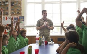 New Zealand Army dentist Lieutenant Tim Reiber asks the students a question during a class on Healthy lifestyles.
