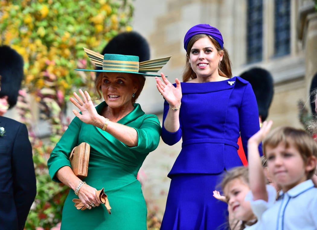 Sarah Ferguson, Duchess of York (left) and her daughter Princess Beatrice of York wave off Princess Eugenie from St George's Chapel in Windsor, on 12 October, 2018 after their wedding ceremony.