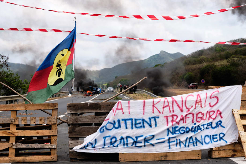 Opponents of the proposed sale of the Vale NC plant display independent Kanak flags on a filter dam on the outskirts of the agglomeration of Noumea.