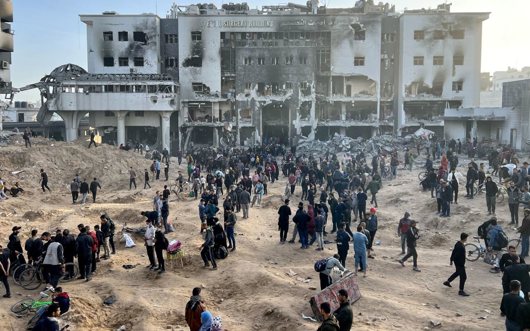 Palestinians gather around the heavily damaged Al-Shifa Hospital, in Gaza City