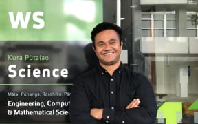 Dr Taniela Lolohea stands in front of the Science building on the AUT campus. He is smiling and has his arms folded.