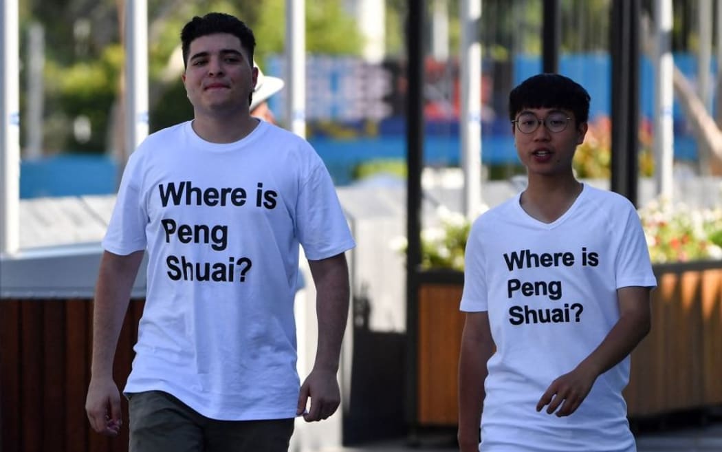 Australian human rights campaigner Drew Pavlou (L) is pictured wearing a "Where is Peng Shuai?" T-shirt, referring to the former doubles world number one from China, at the Australian Open tennis tournament in Melbourne on January 25, 2022.