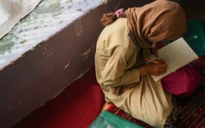 This picture taken on July 25, 2022 shows a girl studying in a secret school at an undisclosed location in Afghanistan.