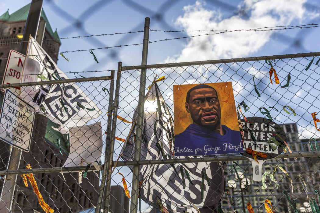A poster with George Floyd's picture and a sign reads that "I Can't Breathe" hang from a security fence outside the Hennepin County Government Center in Minneapolis, Minnesota.