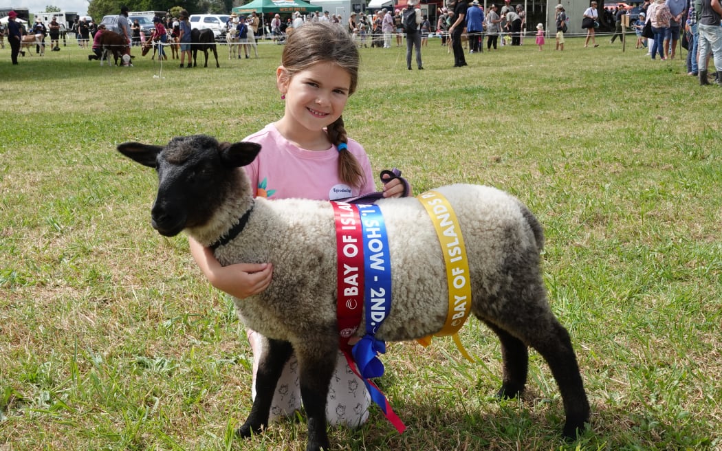 Six-year-old Marlow Campbell from Ruatangata, near Whangārei, with Berry, her multi-prize-winning Suffolk lamb.