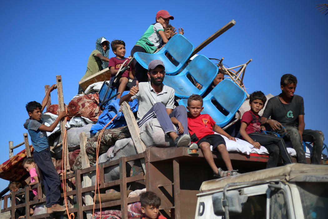 Displaced Palestinians move with their belongings southwards on a road in the Nuseirat refugee camp area in the central Gaza Strip following renewed Israeli evacuation orders for Gaza City on September 16, 2025. Israel launched its long-anticipated ground assault on Gaza City at dawn on September 16, a day after winning backing from its top ally the United States despite mounting international alarm. (Photo by Eyad BABA / AFP)